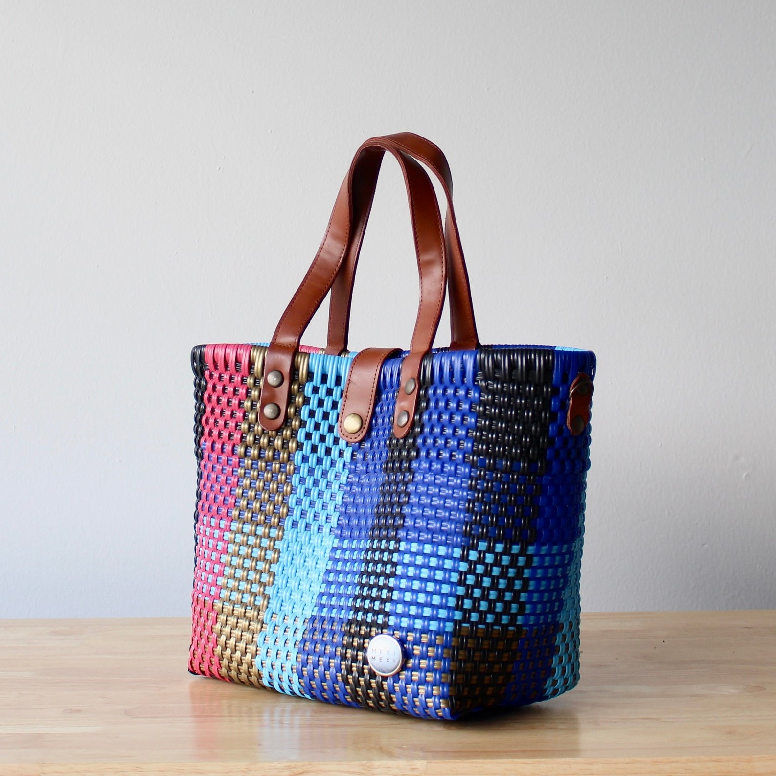 Close-up of artisan woven pattern in blue, pink, and gold – handmade Mexican bag