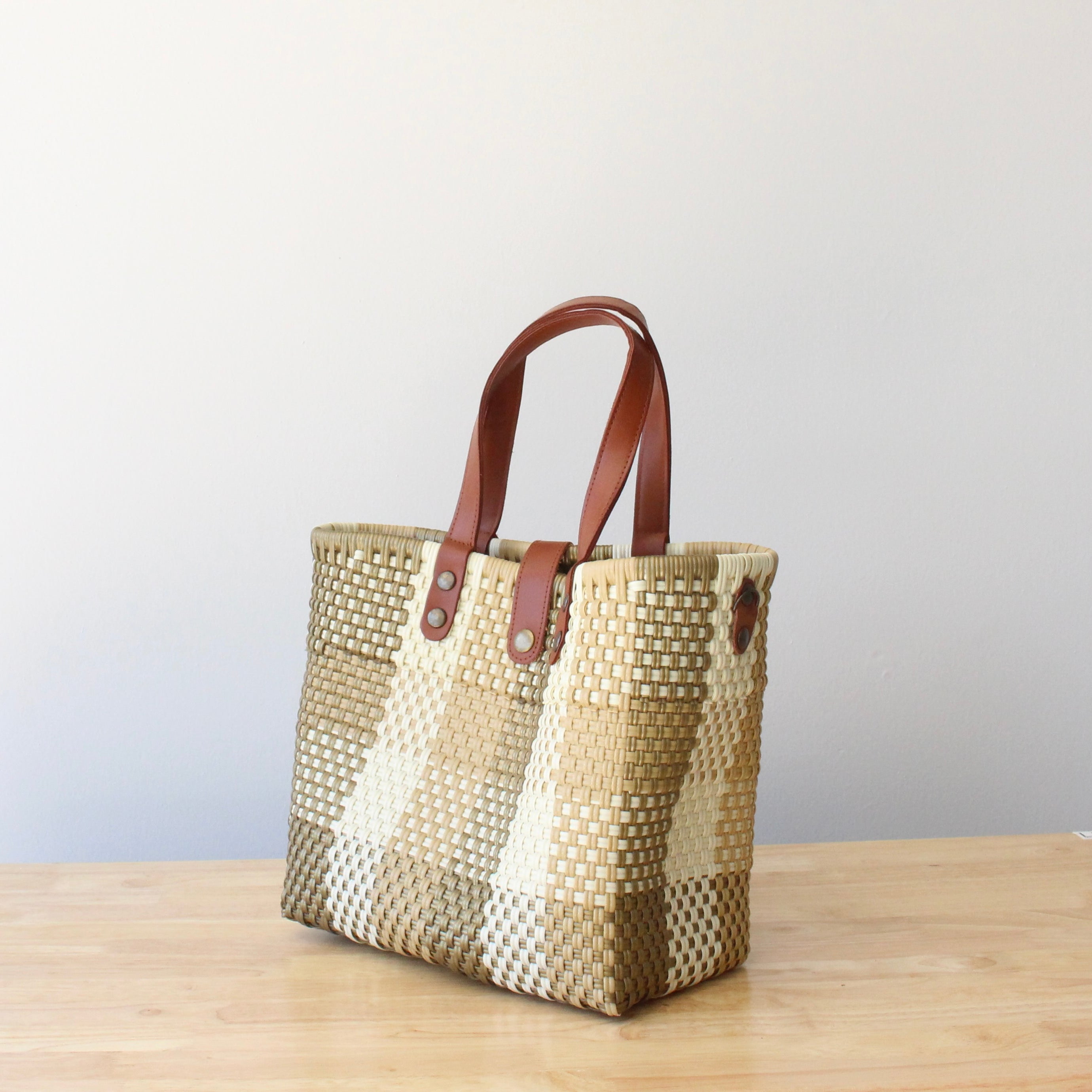 Side view of eco-friendly recycled plastic purse with durable brown leather handles