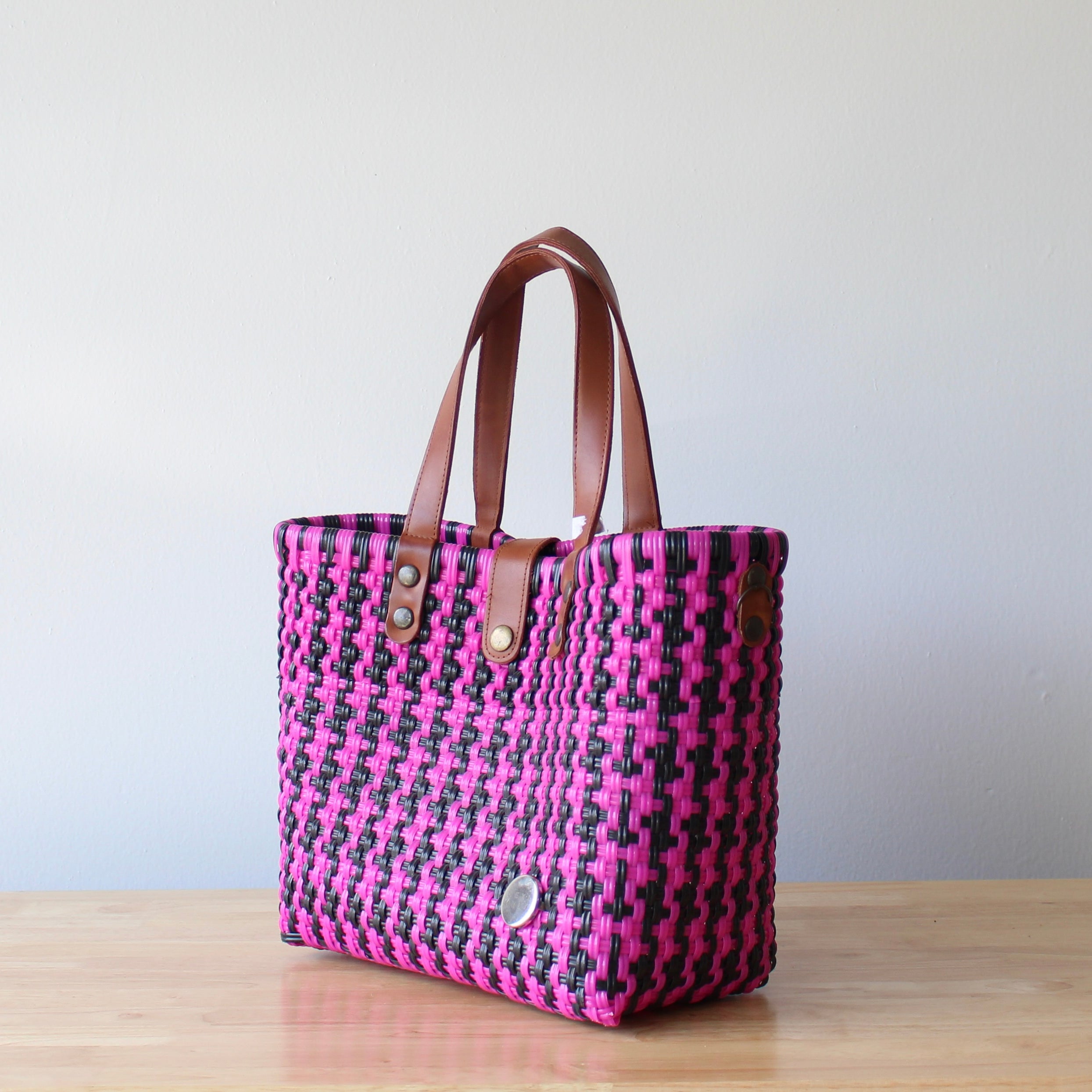 Handbag with pink and black pattern on a wooden surface