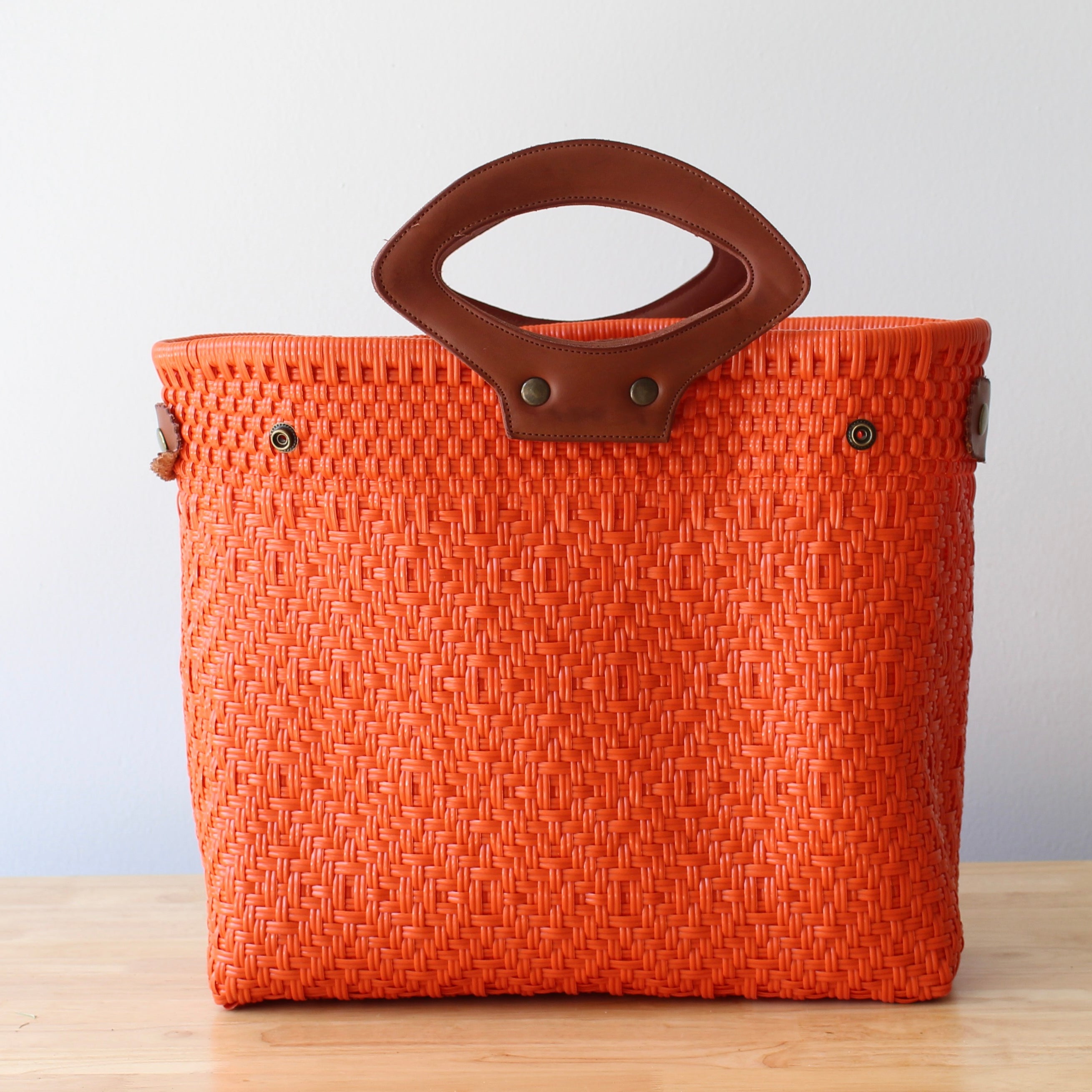 Large orange tote bag with leather accents for daily use