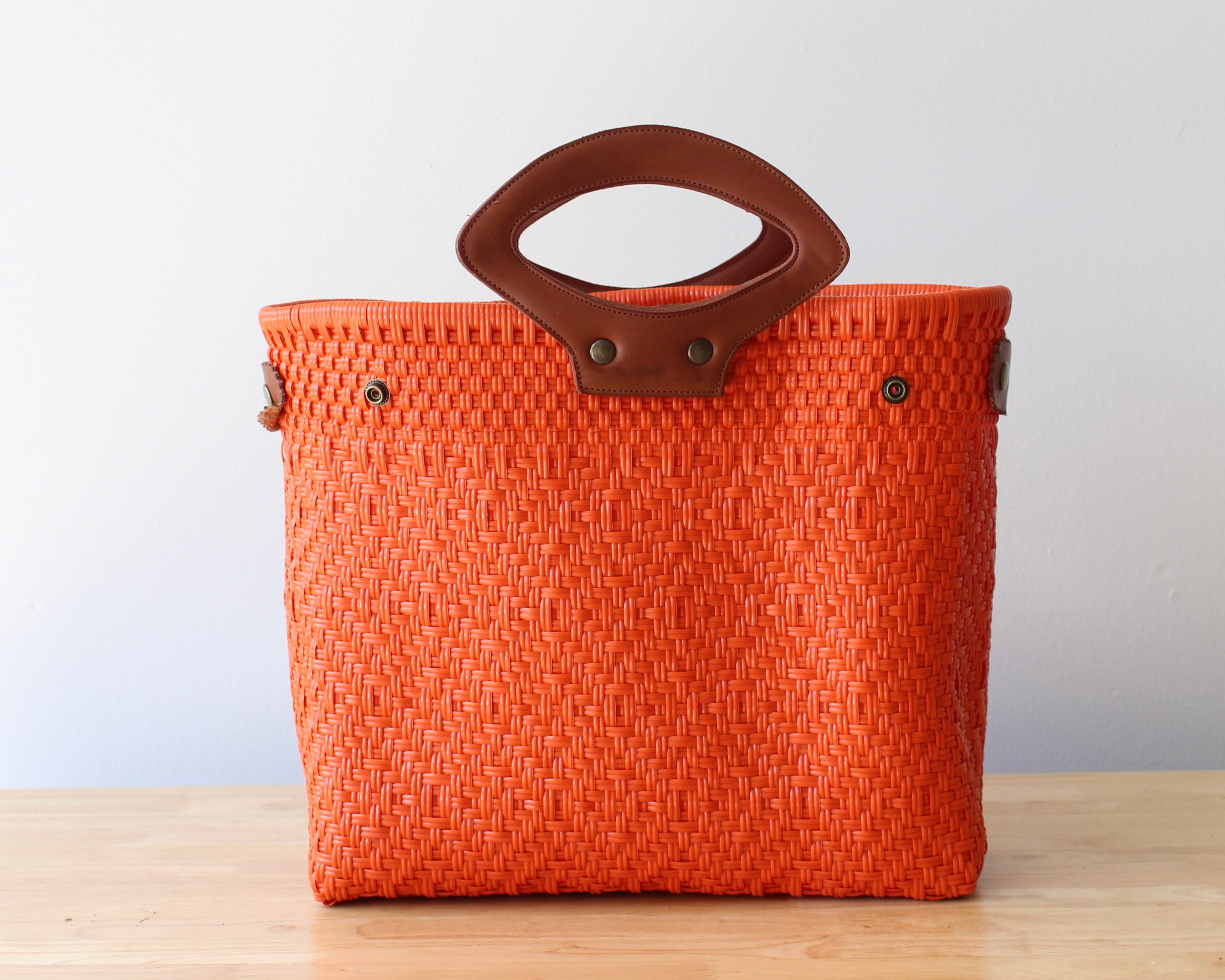 Large orange tote bag with leather accents for daily use