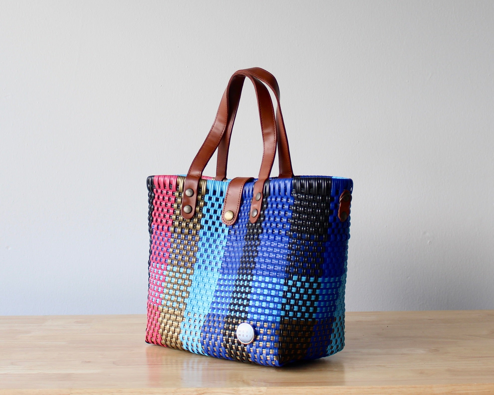 Close-up of artisan woven pattern in blue, pink, and gold – handmade Mexican bag
