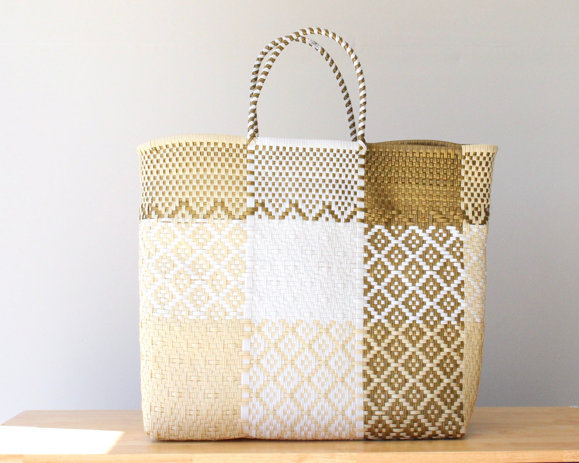 Woven tote bag with geometric pattern on a wooden surface