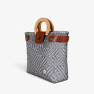 Silver gray handwoven basket bag with wood handles and brass-tone twist lock, angled view