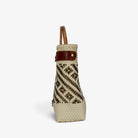 Side view of the cream and gold basket bag showing its adjustable leather side strap