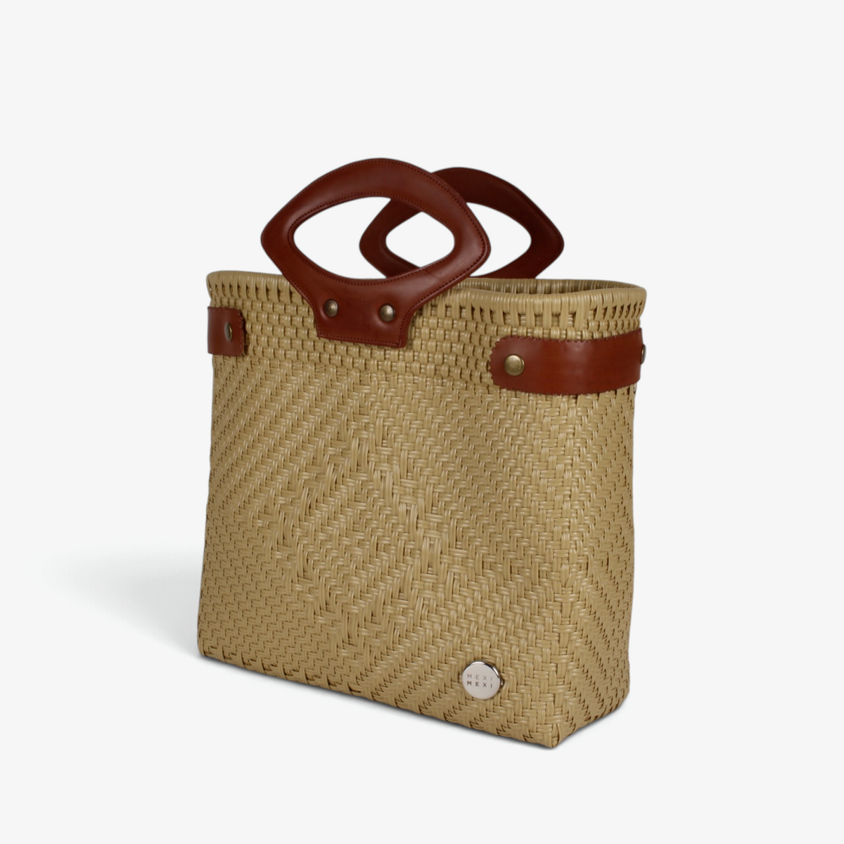 Sandy tan handwoven basket bag with brown genuine leather handles and snap side straps, angled view