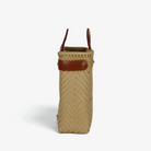 Side view of the khaki woven tote showing its adjustable leather side strap