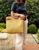 Khaki Laura Maria Mexican basket tote with brown leather handles, lifestyle photo