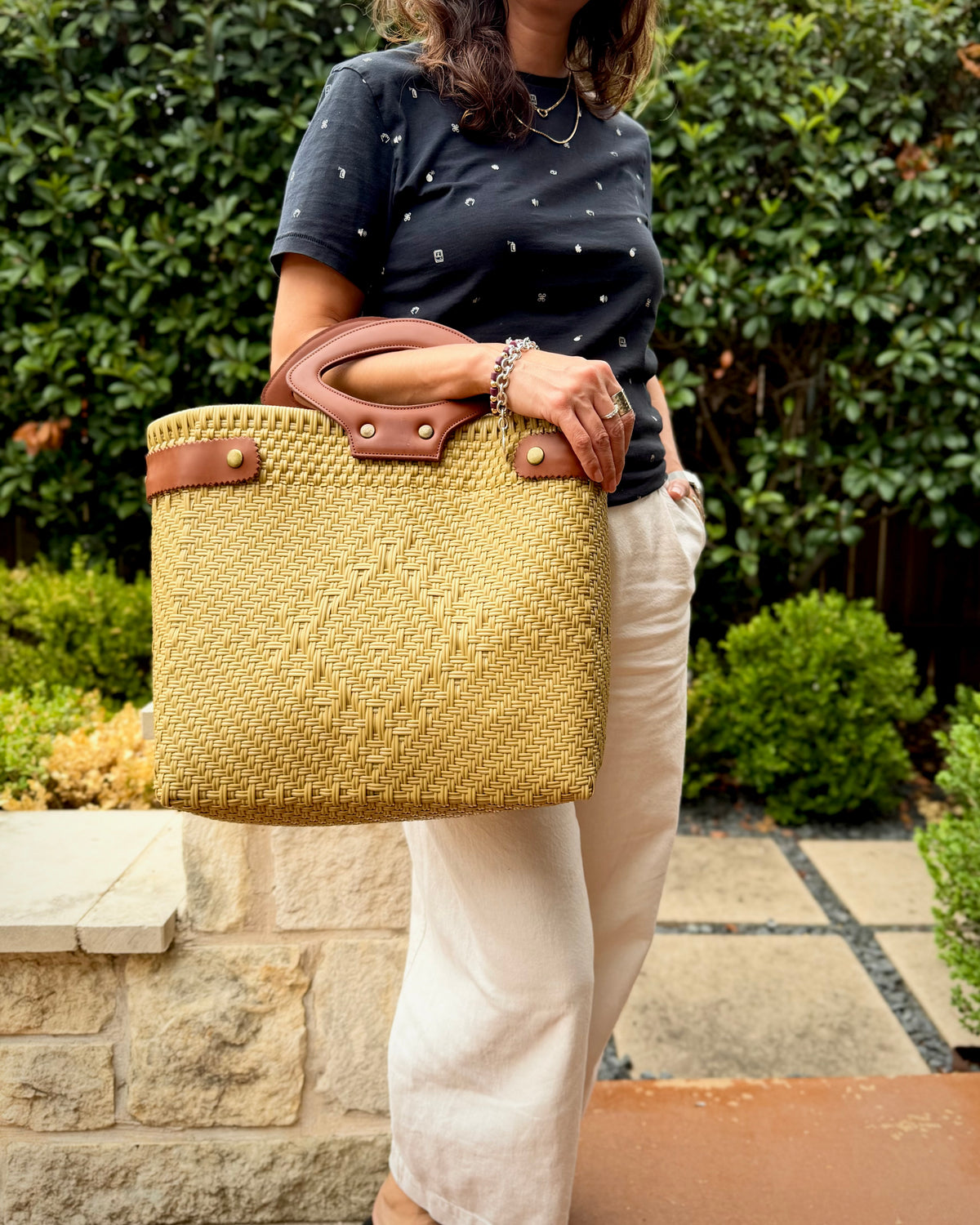 Khaki Laura Maria Mexican basket tote with brown leather handles, lifestyle photo