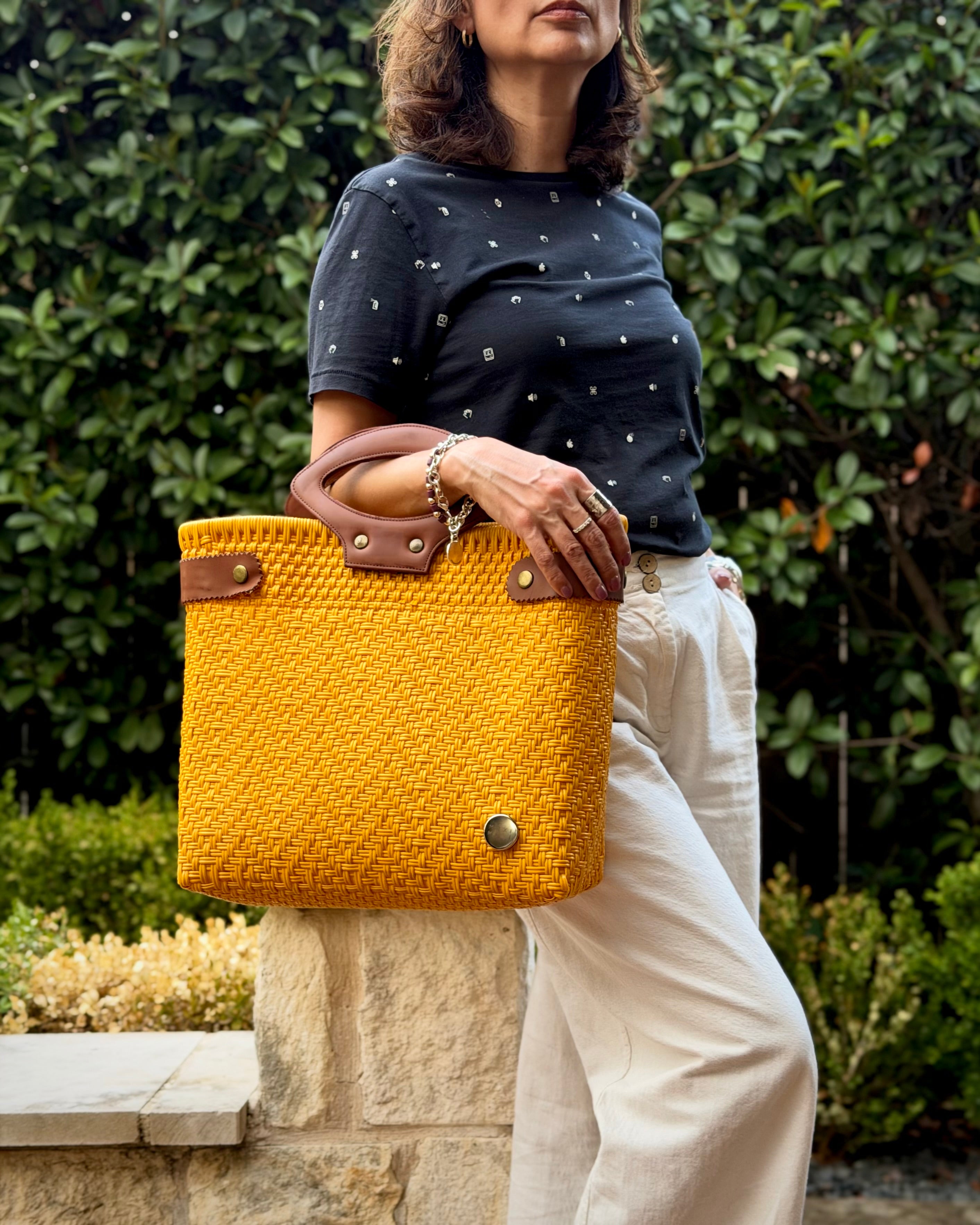 Mustard Yellow Laura Maria Mexican basket tote with brown leather handles, lifestyle photo