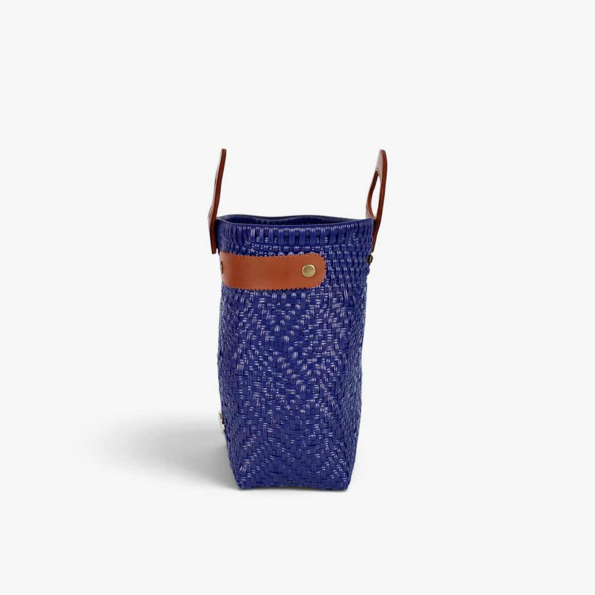 Side view of the royal blue woven tote showing its adjustable leather side strap