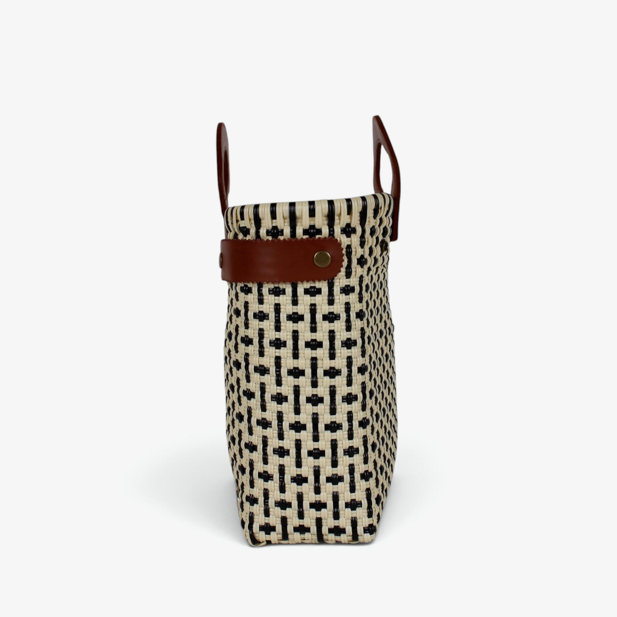 Side view of the black and cream check tote showing its adjustable leather side strap