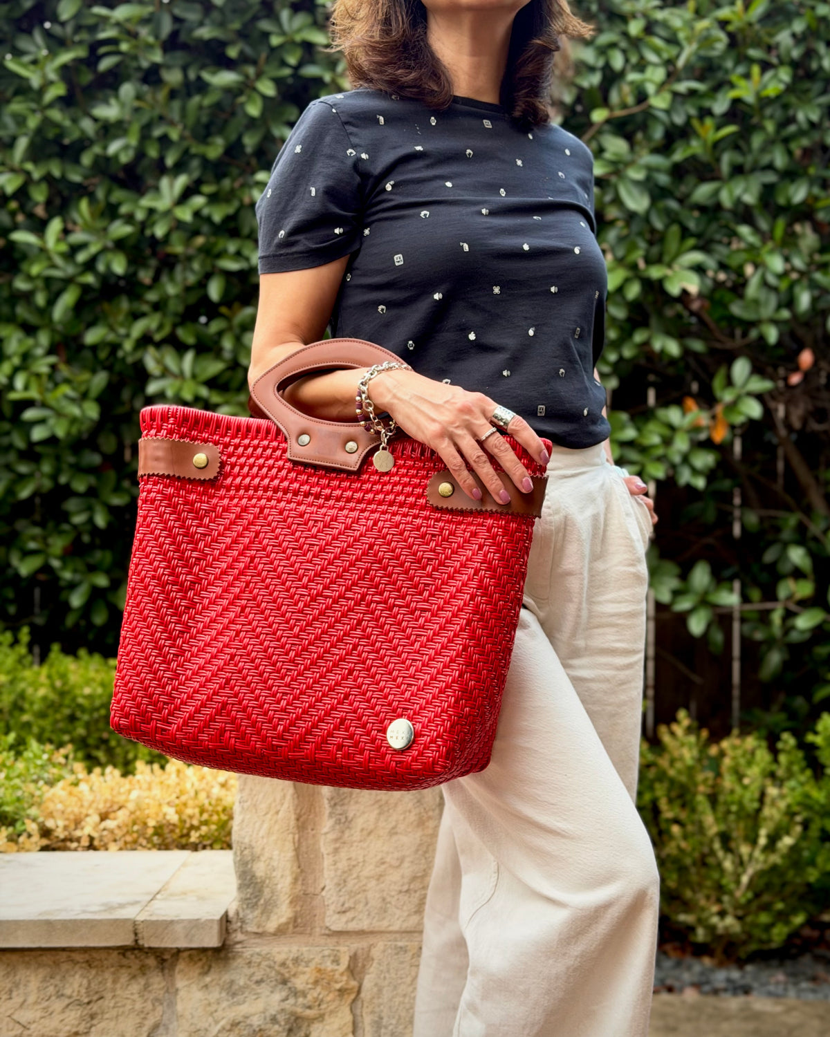 Red Laura Maria Mexican basket tote with brown leather handles, lifestyle photo