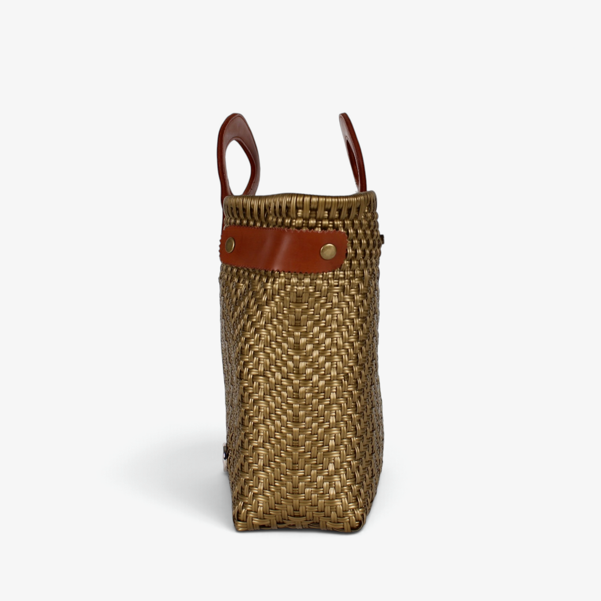 Side view of the bronze woven tote showing its adjustable leather side strap