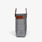 Side view of the gray woven tote showing its adjustable leather side strap