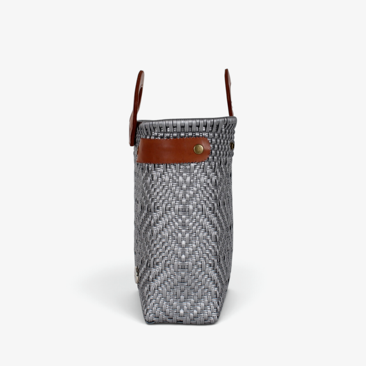 Side view of the gray woven tote showing its adjustable leather side strap
