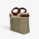 Tan and black diamond woven basket bag with brown genuine leather handles, angled view