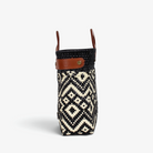 Side view of the black and ivory diamond basket bag showing its adjustable leather side strap