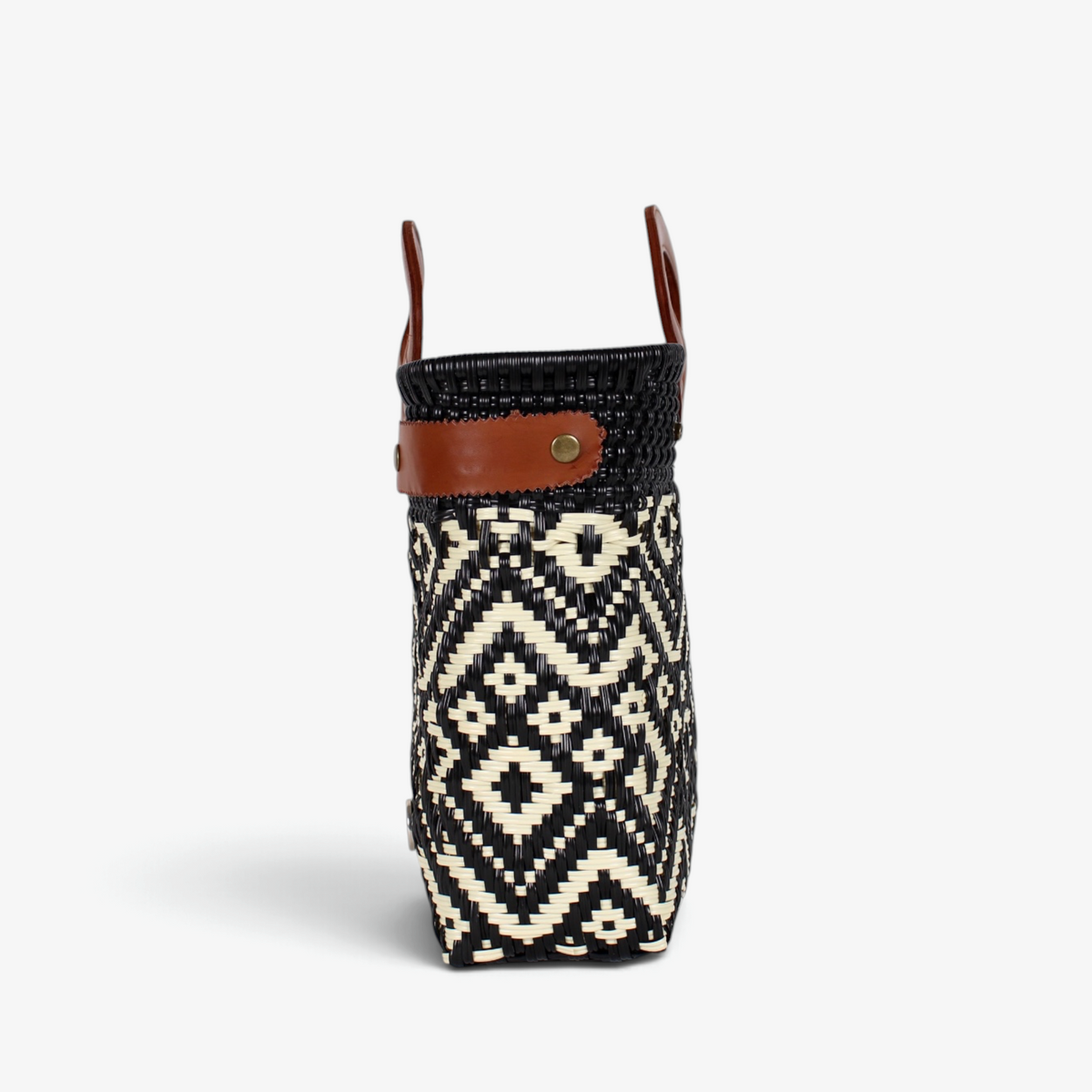 Side view of the black and ivory diamond basket bag showing its adjustable leather side strap
