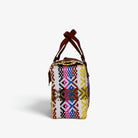 Side view of the multicolor diamond woven handbag with leather flap and snap closure