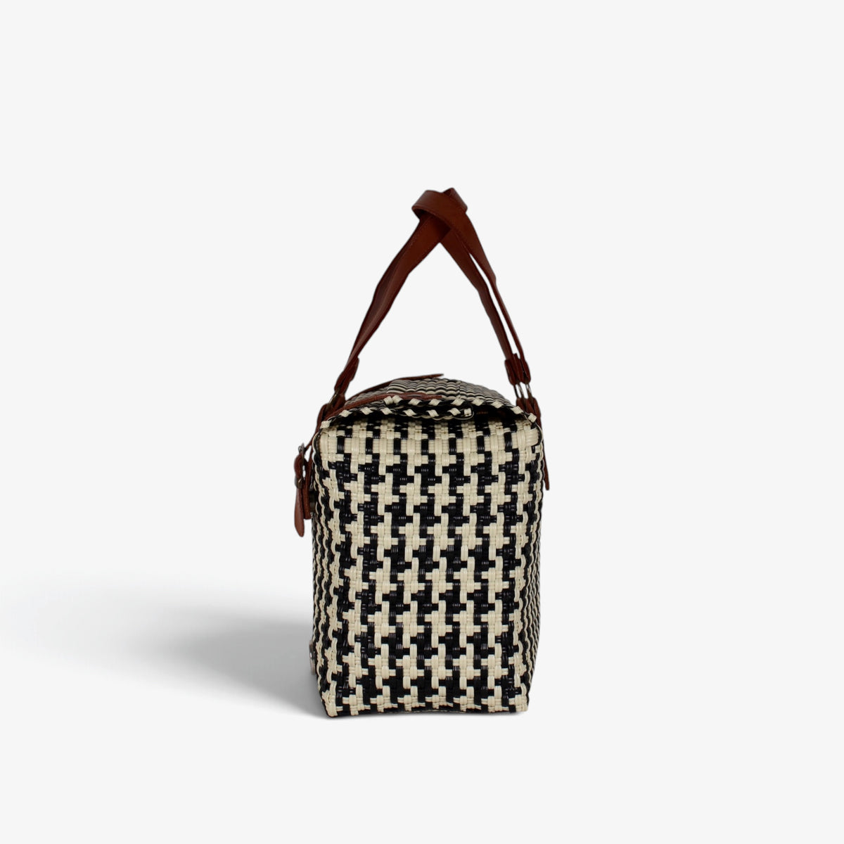 Side view of the black and cream houndstooth woven handbag with leather flap and snap closure