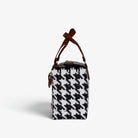 Side view of the black and white houndstooth woven handbag with leather flap and snap closure