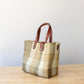 Side view of eco-friendly recycled plastic purse with durable brown leather handles