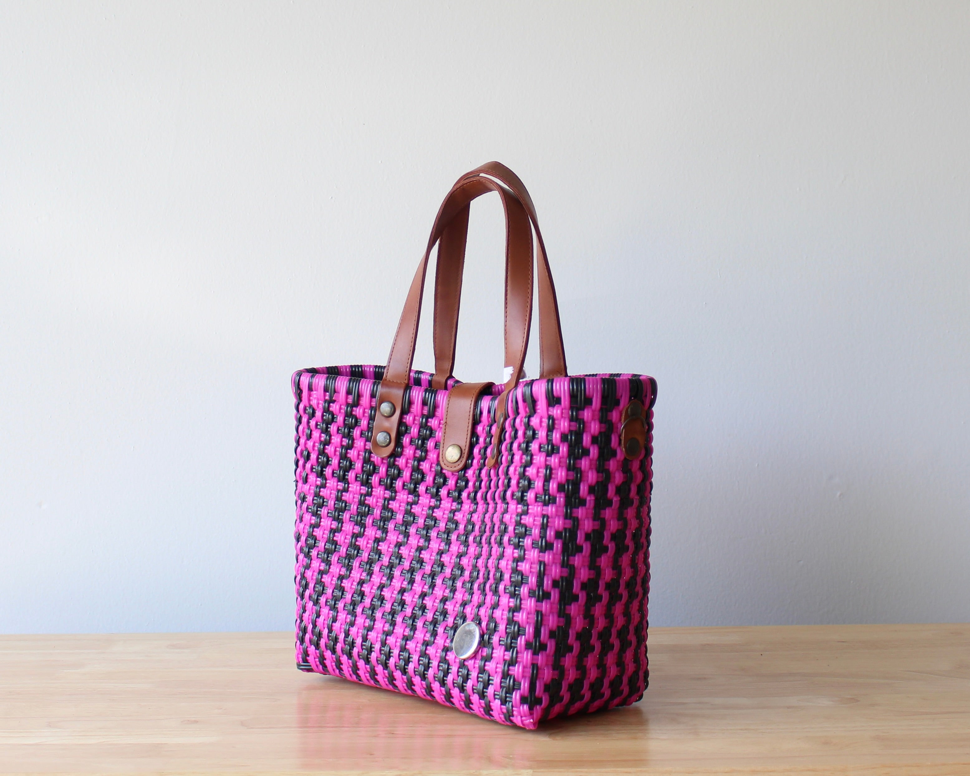 Handbag with pink and black pattern on a wooden surface