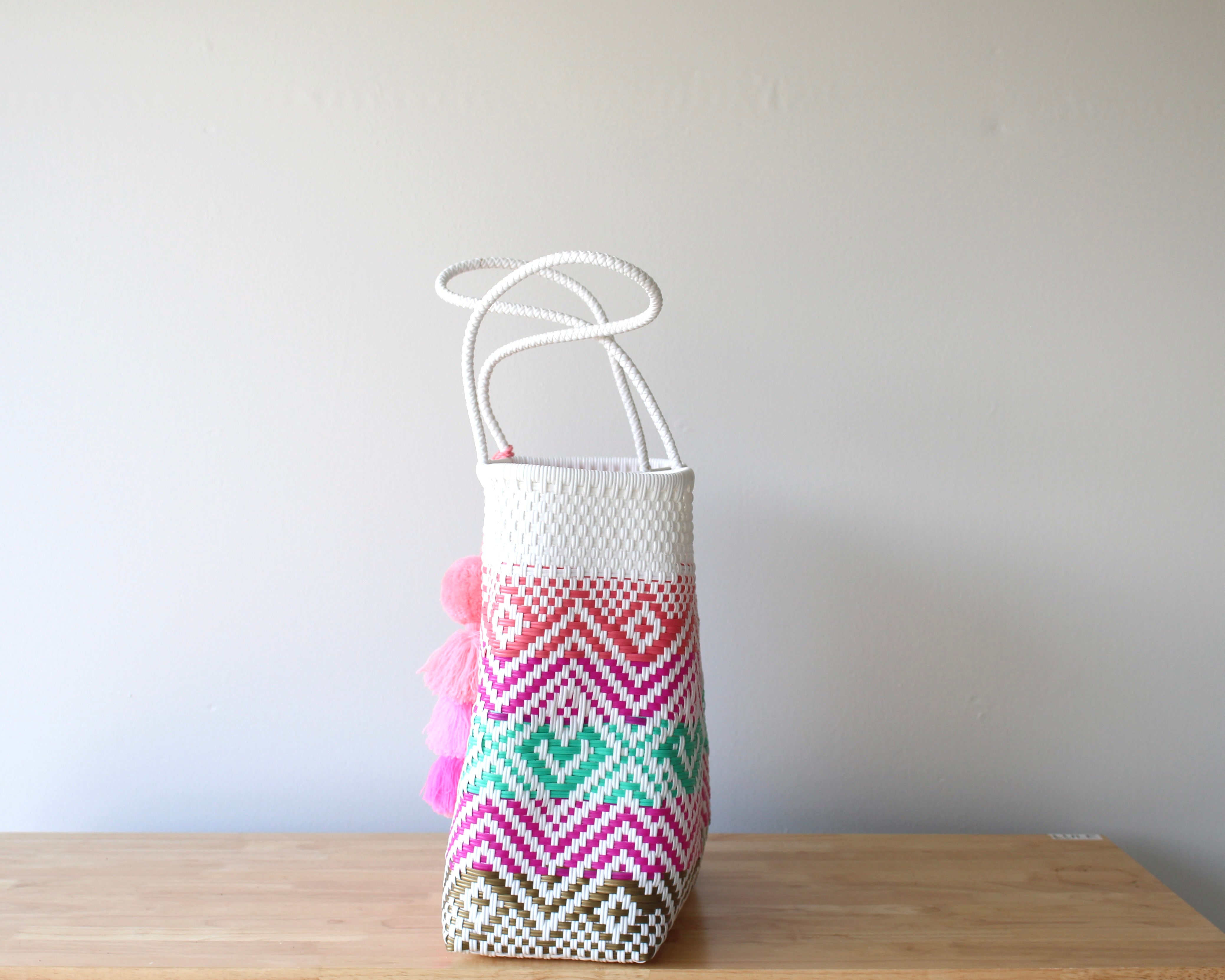 White Artisan handbag with colorful geometric pattern, in White and colorful tones with a pom pom charm.