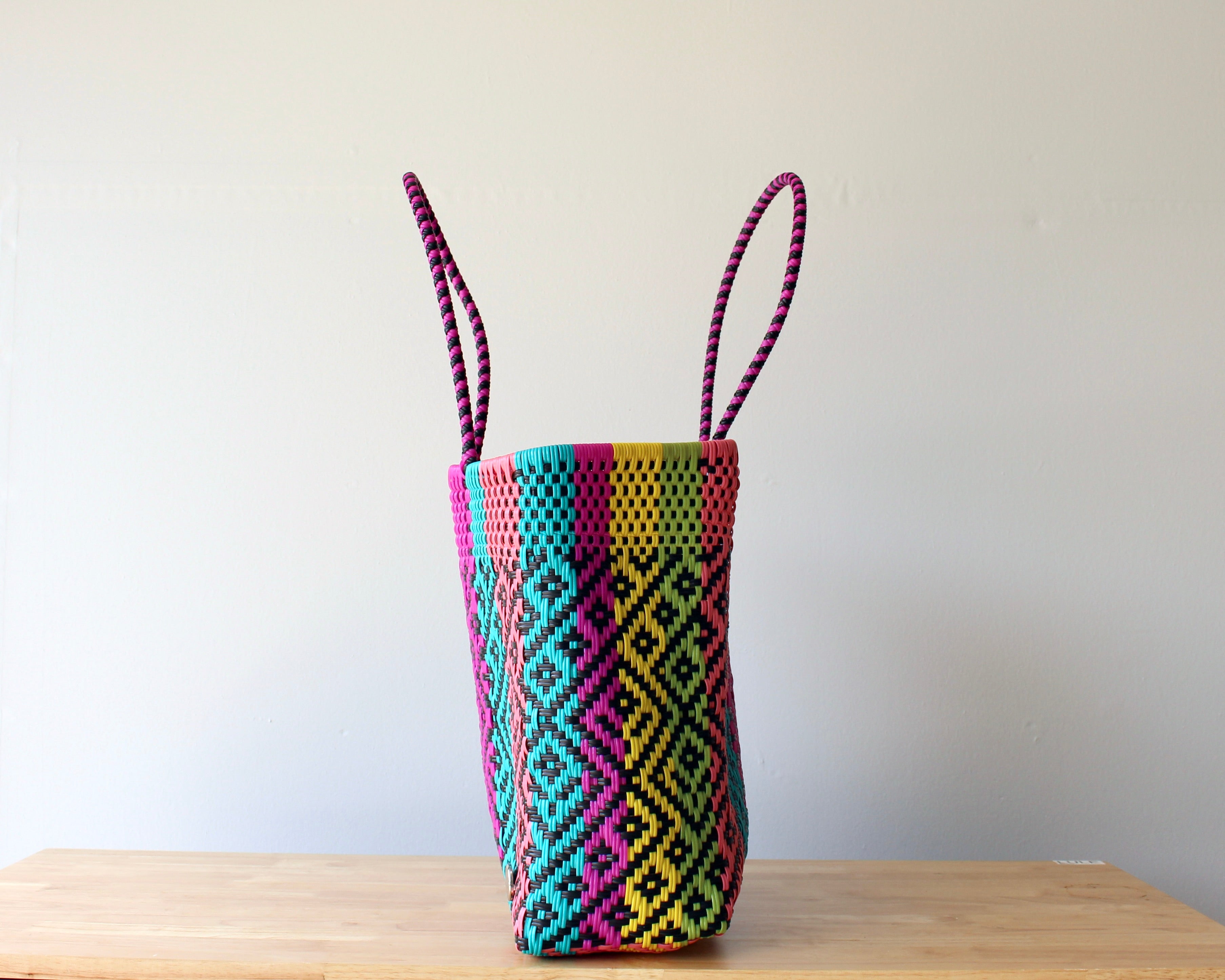 Diagonal view of rainbow woven Mexican tote — waterproof artisan bag by MexiMexi