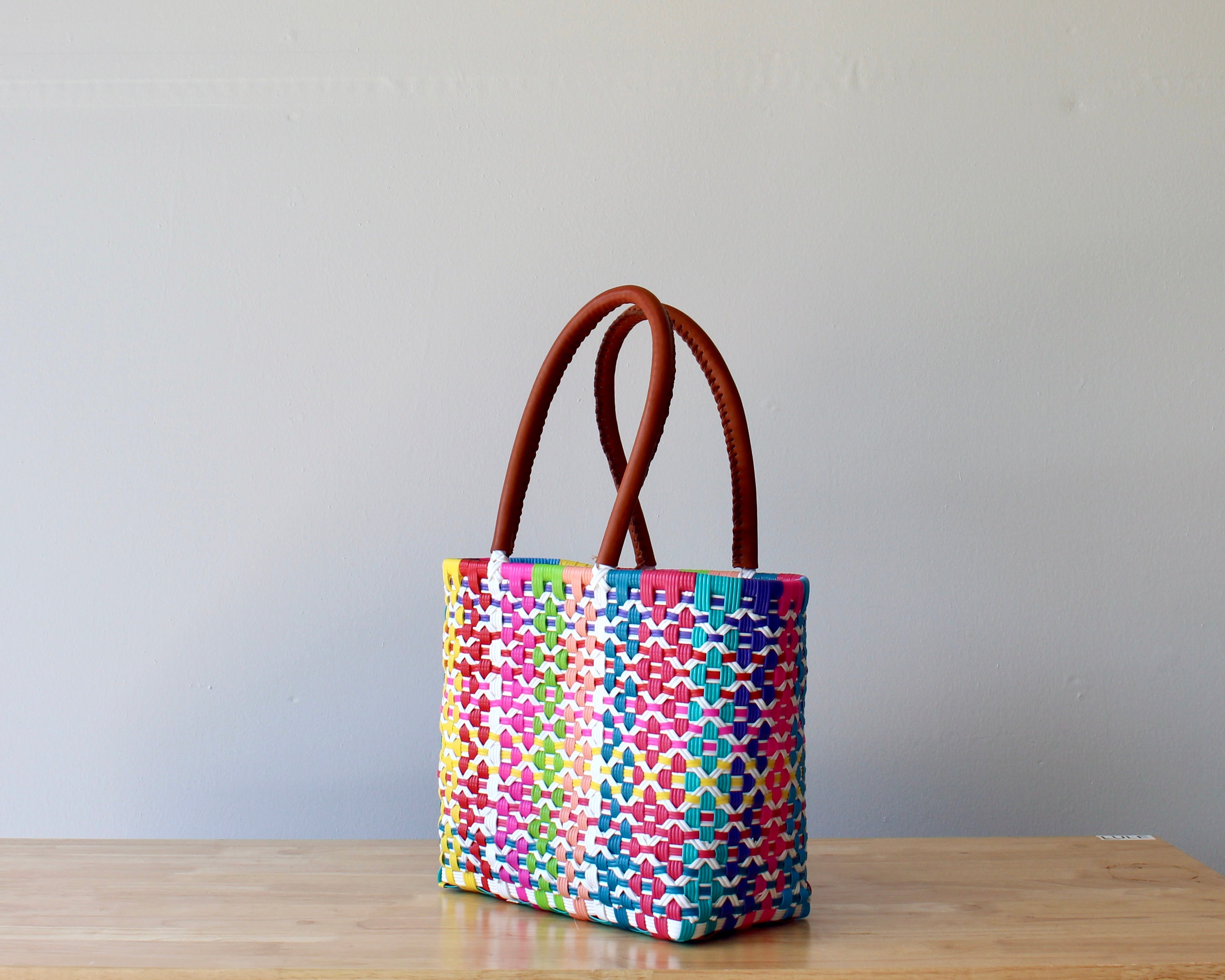 Diagonal view of vibrant pink woven Mexican tote — waterproof artisan bag by MexiMexi