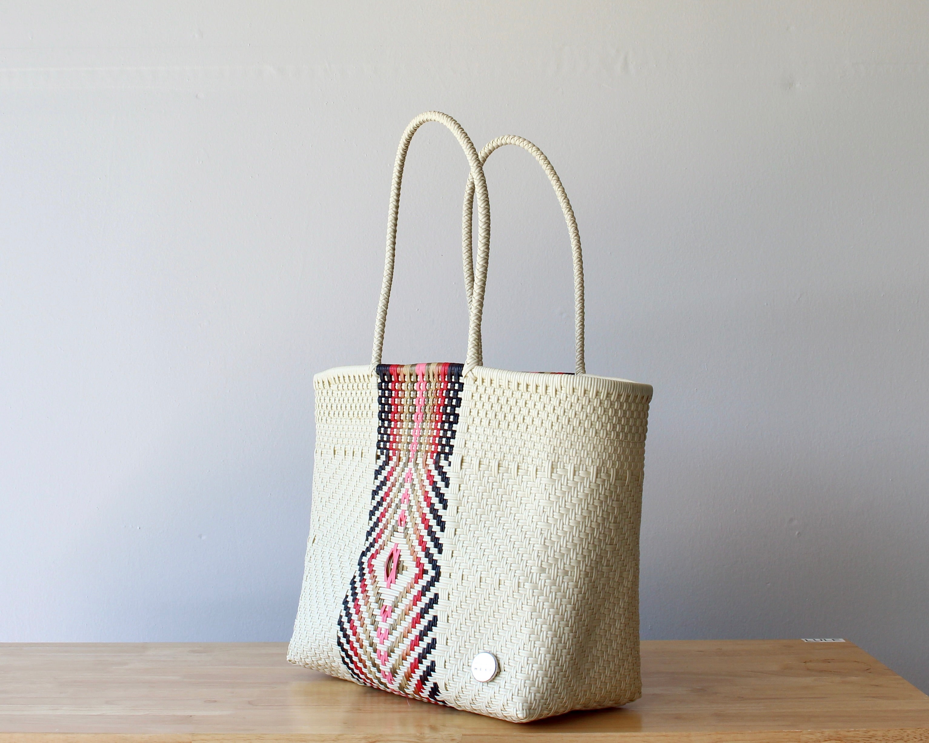 Diagonal view of the beige and rose woven artisan tote — waterproof Mexican bag by MexiMexi
