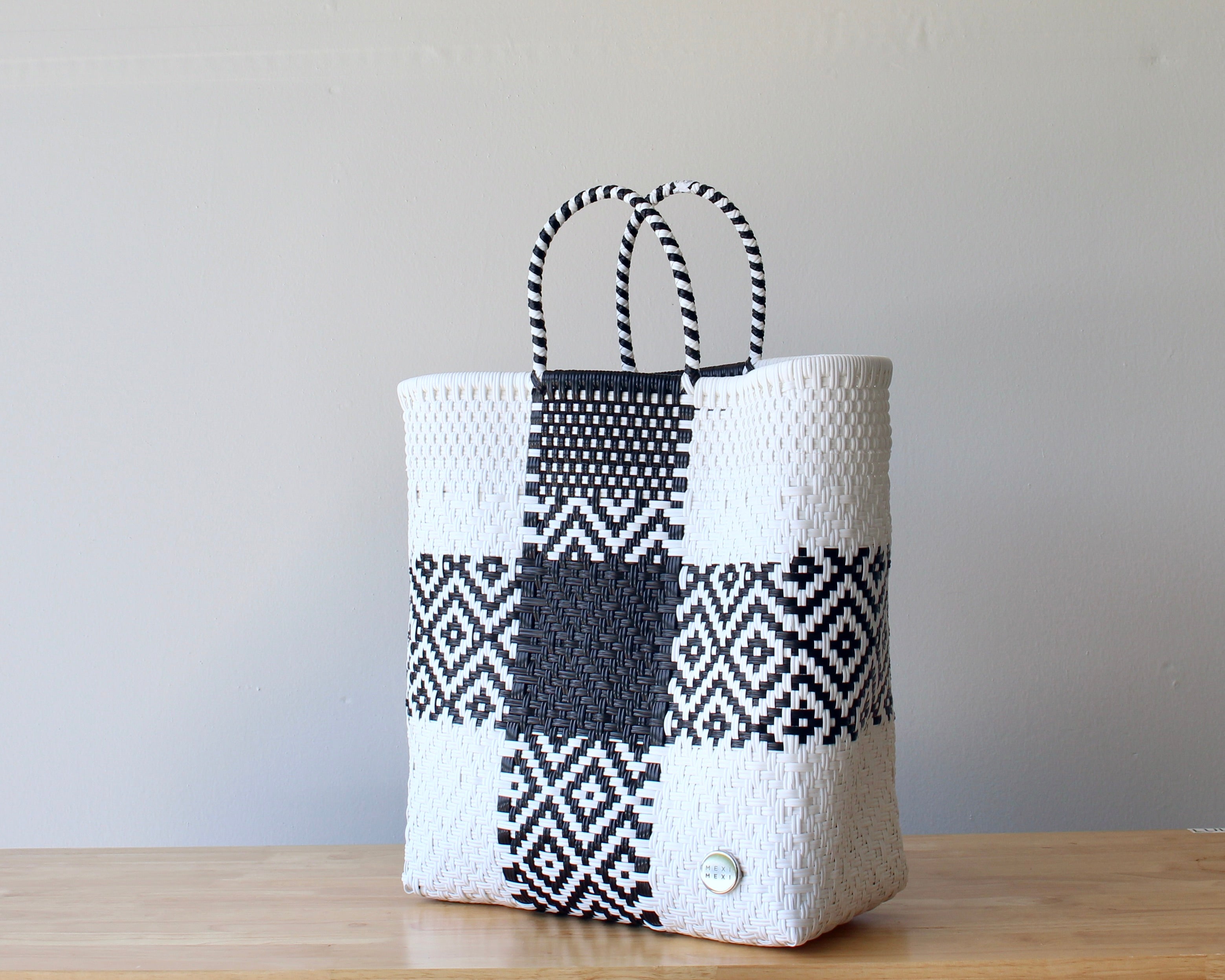 Diagonal view of classic black and white woven tote — waterproof artisan bag by MexiMexi