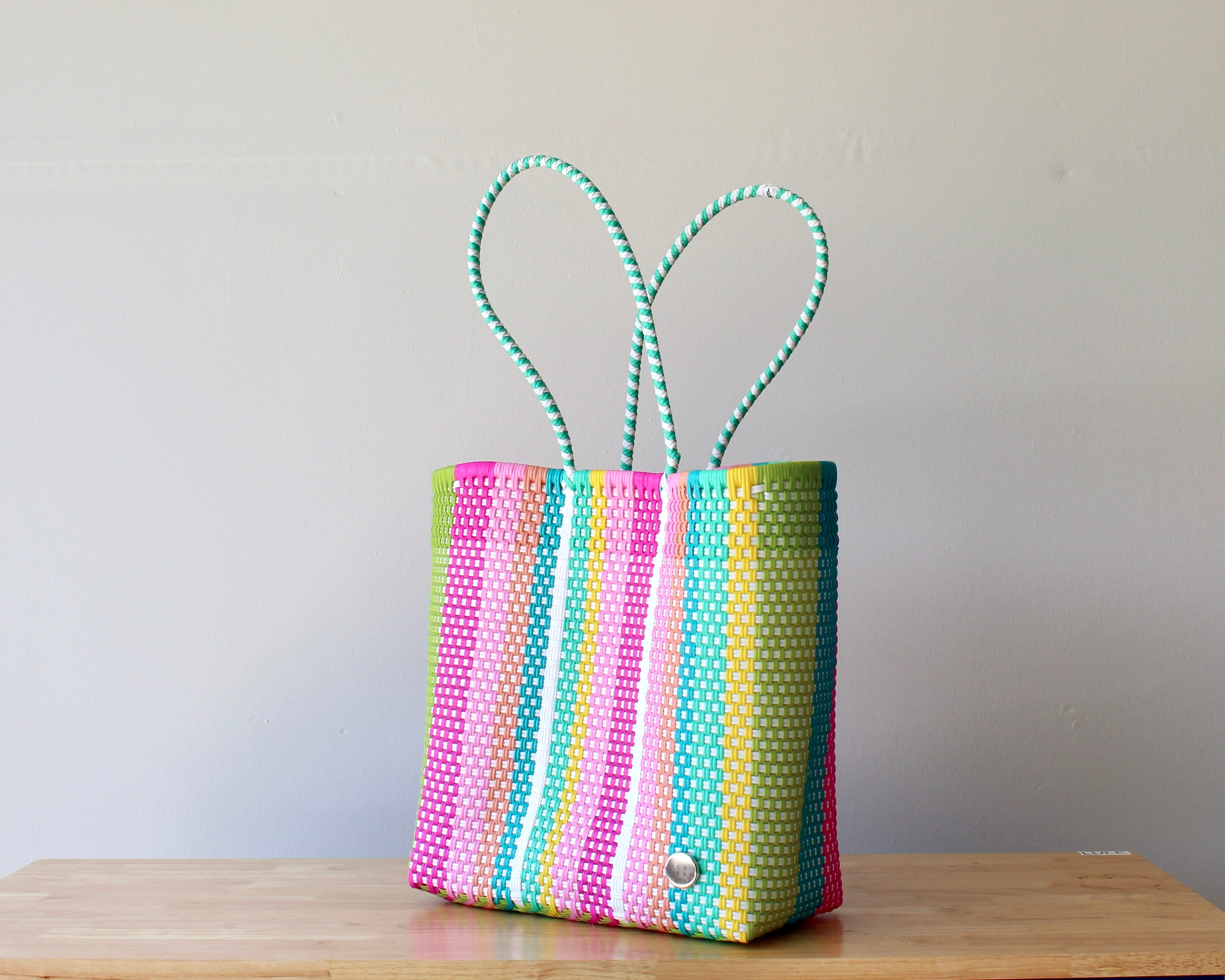 Diagonal view of multicolor stripe woven tote — waterproof artisan bag by MexiMexi