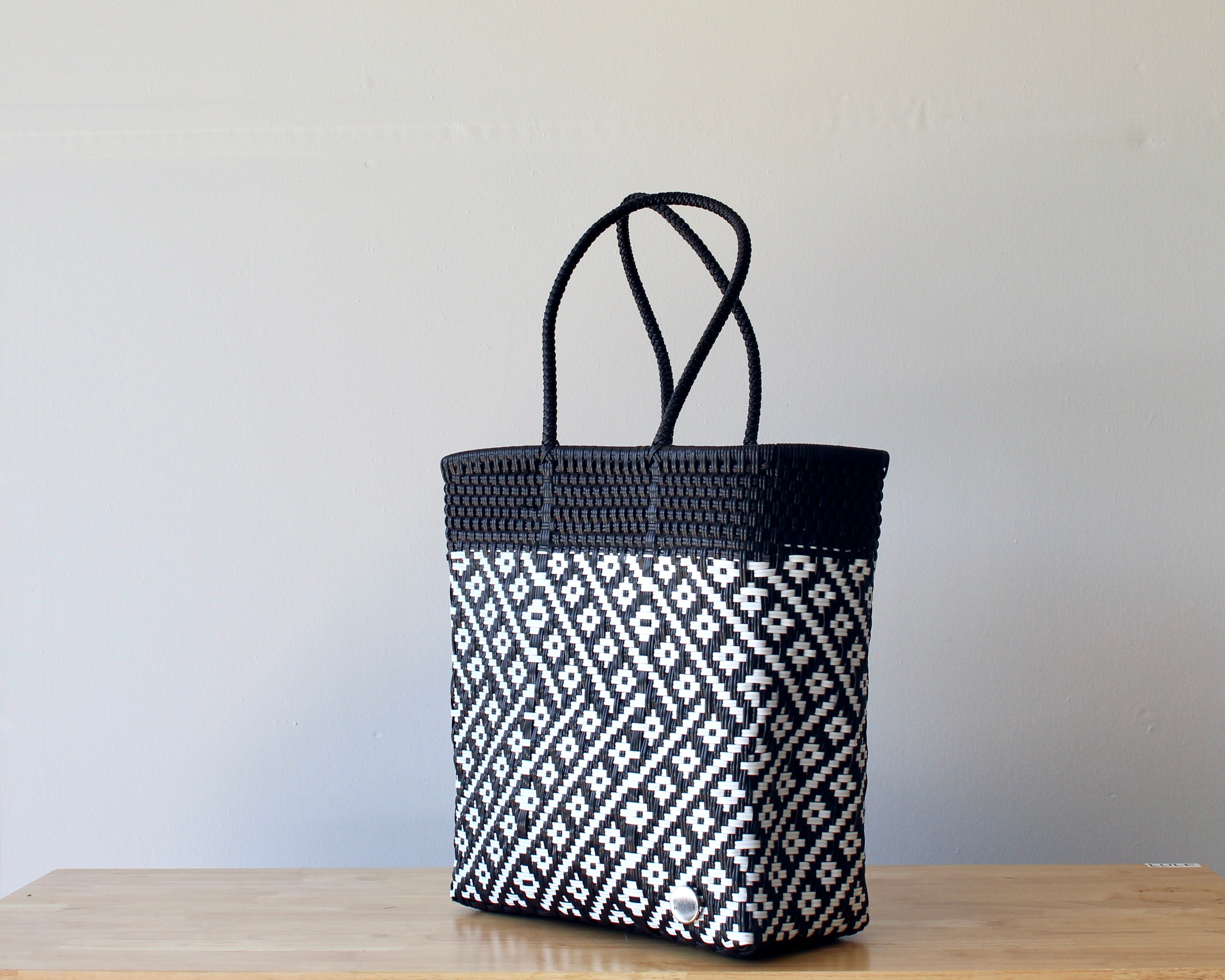 Diagonal view of black and white two-tone woven tote — waterproof artisan bag by MexiMexi