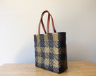 Gold and black checkered handwoven Mexican tote bag with leather handles — angled view — Alma Rosa, Domino — MexiMexi