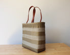 Gold and white handwoven Mexican tote bag with leather handles — angled view — Alma Rosa, Gold — MexiMexi