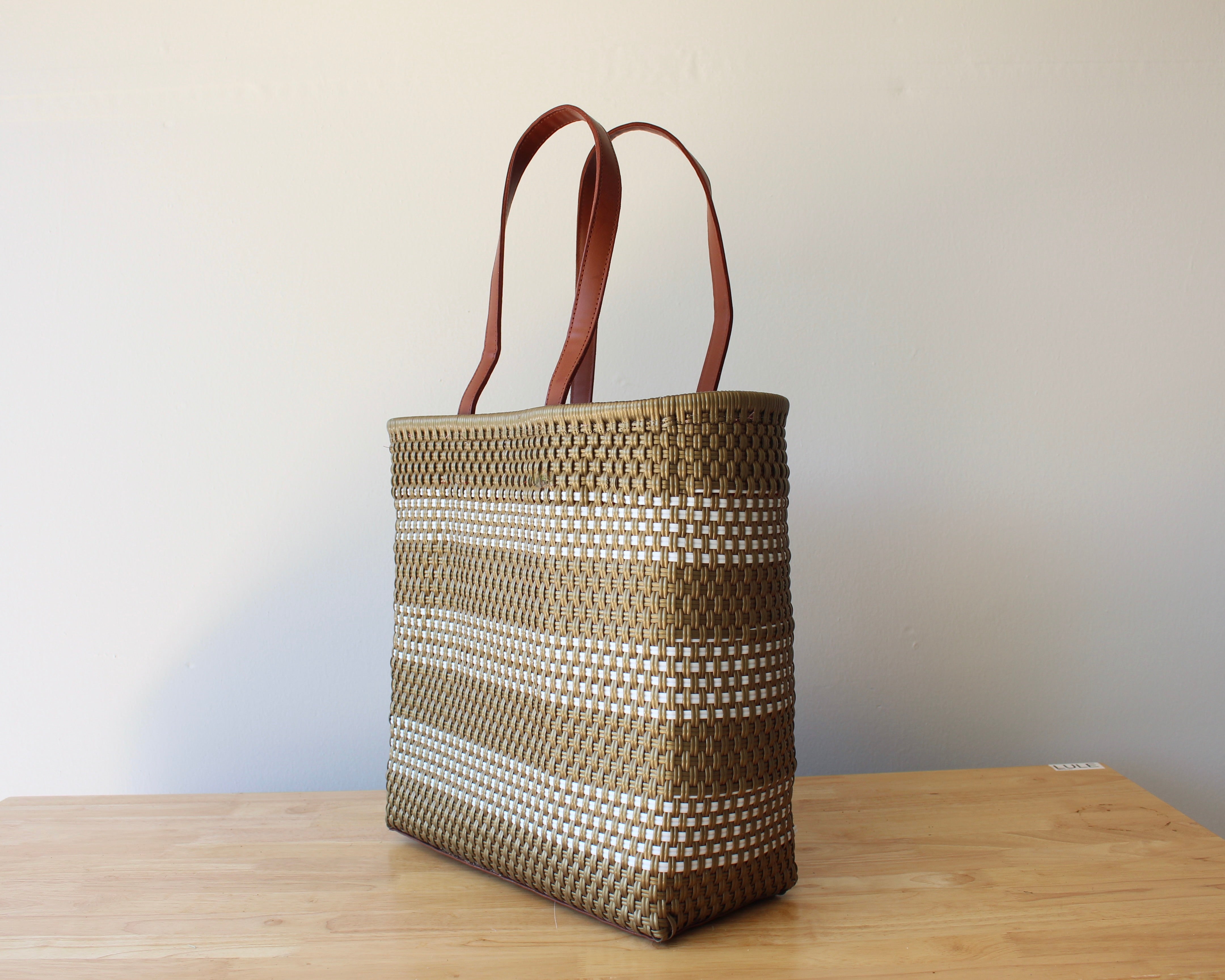 Gold and white handwoven Mexican tote bag with leather handles — angled view — Alma Rosa, Gold — MexiMexi