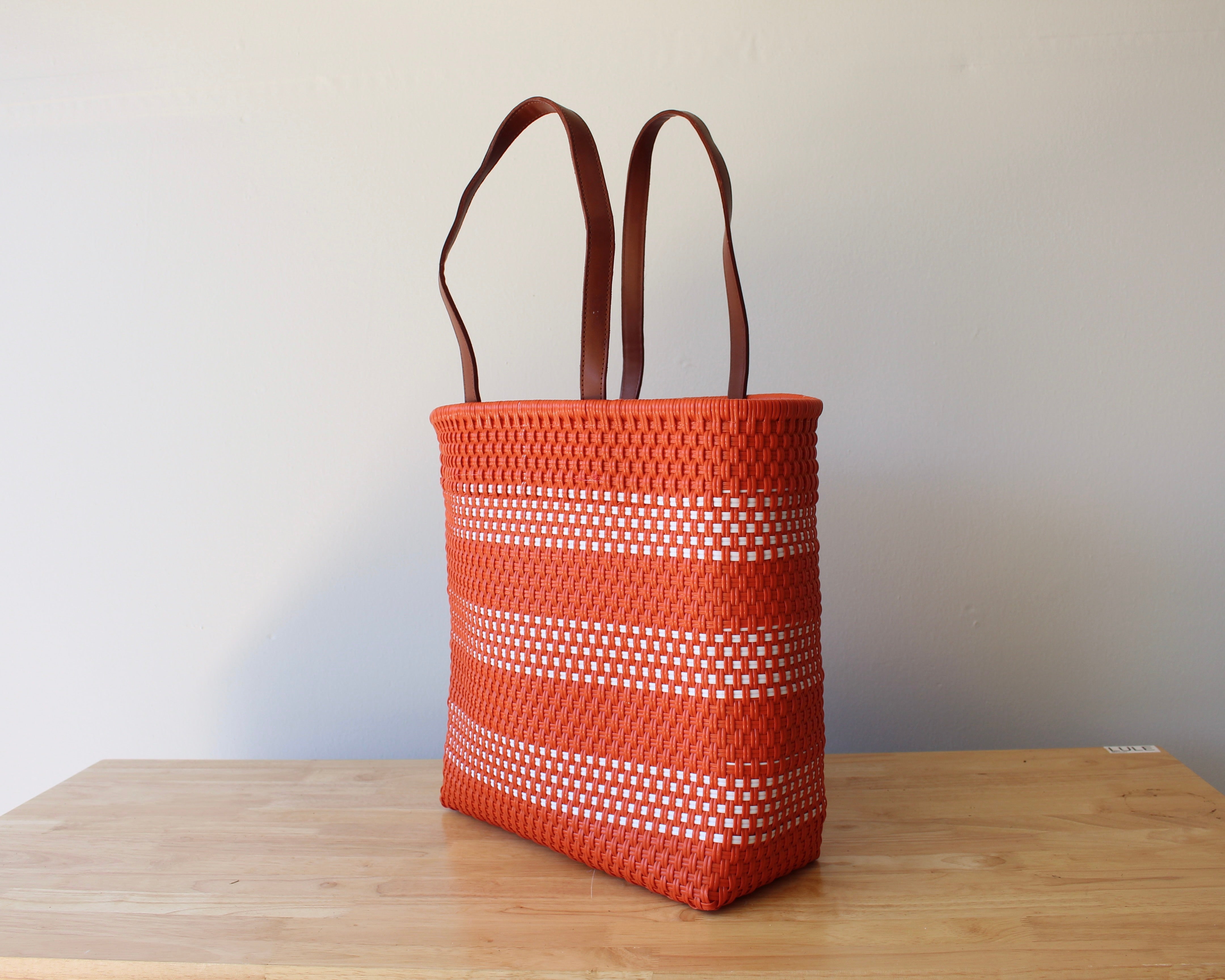 Orange and white handwoven Mexican tote bag with leather handles — angled view — Alma Rosa, Tangerine — MexiMexi