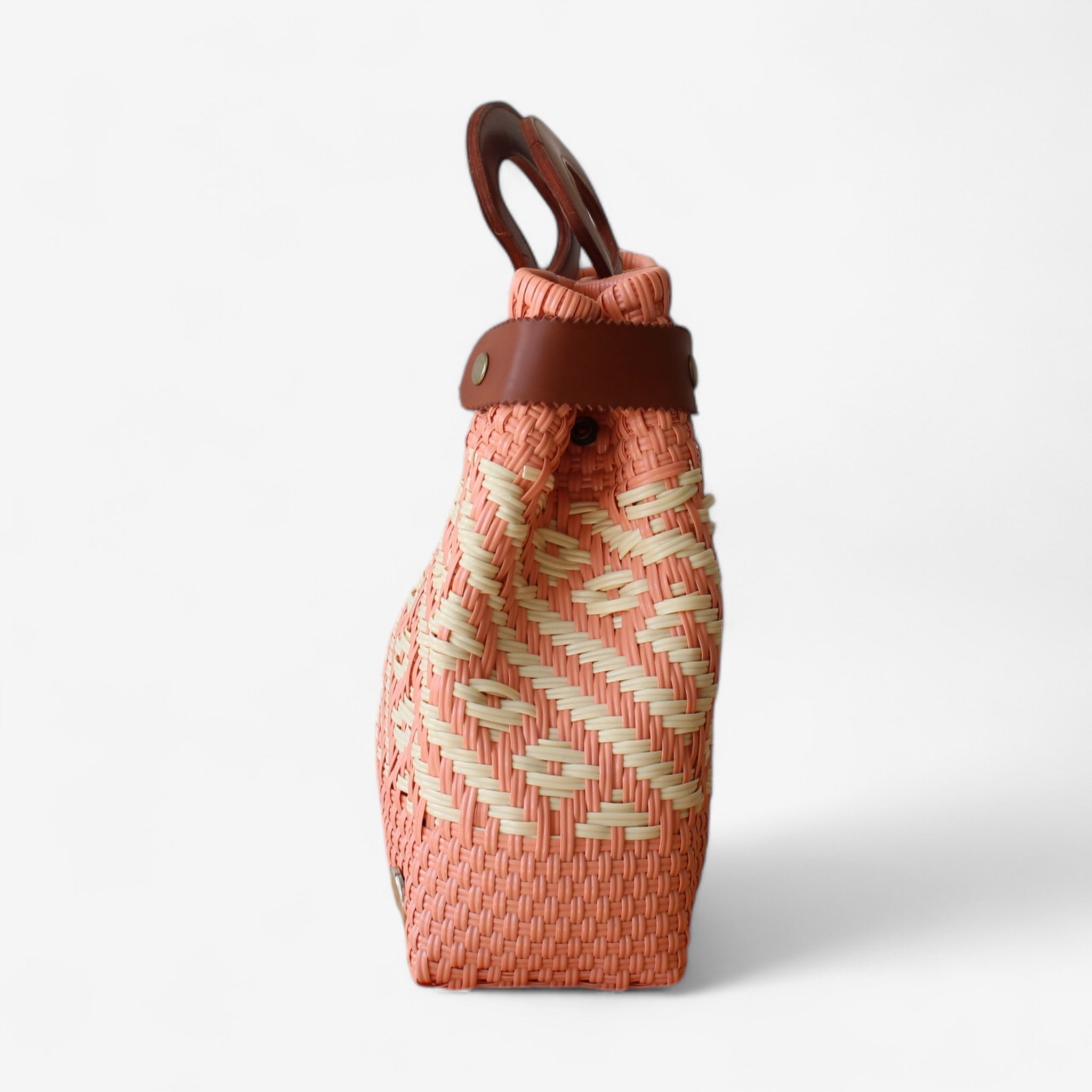 Lightweight handwoven purse in coral and cream with adjustable side straps and leather accents