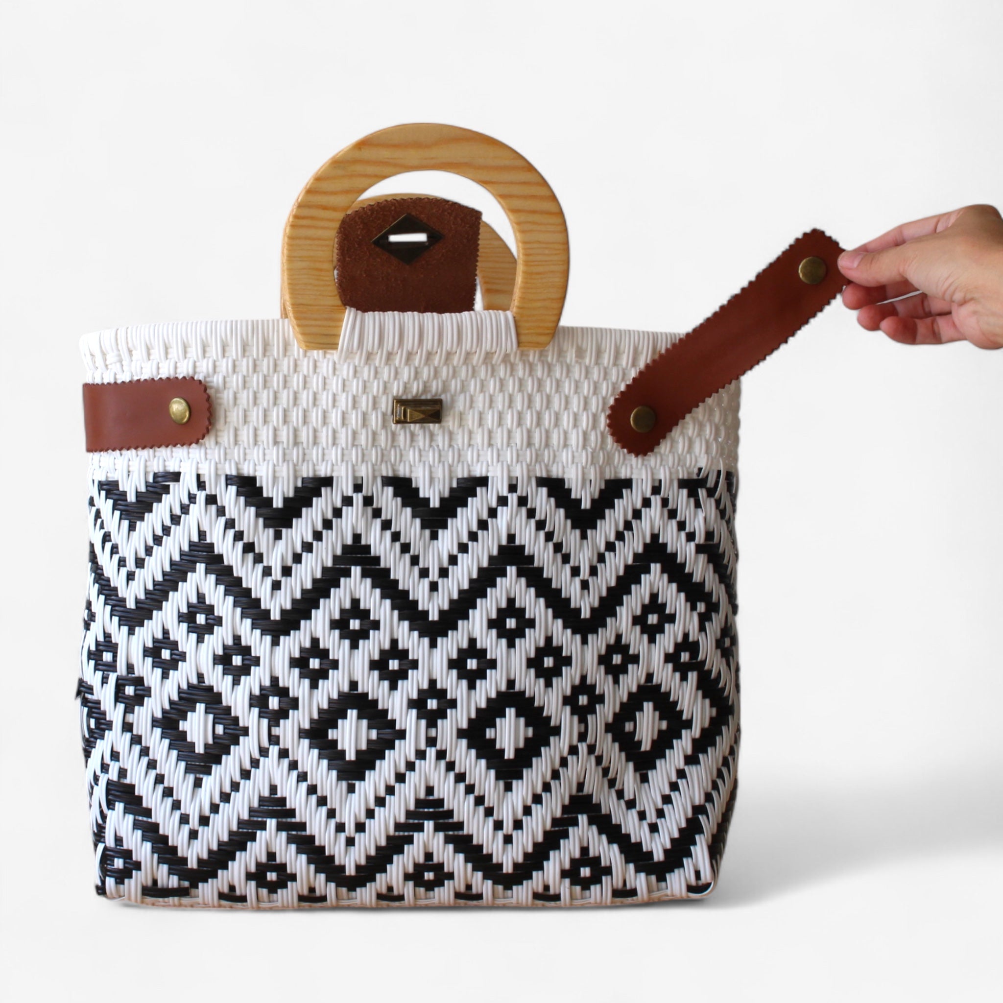 Handwoven black and white purse with geometric design and leather details